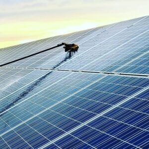water-fed brush being used to clean solar panels